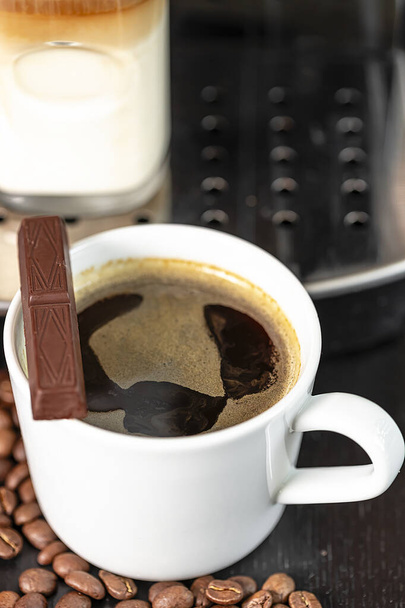 Egy csésze kávé Americano közelkép és egy pohár cappuccino egy kávéfőzőben. Kávét.. - Fotó, kép