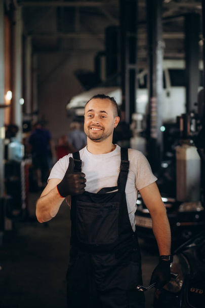 Porträt eines glücklichen Automechanikers, der Hände mit Tuch reinigt. Hochwertiges Foto - Foto, Bild