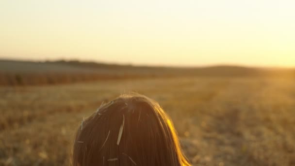 Энергичный детский восторг: лучезарная маленькая девочка, трогающая сено в теплых полях, обнимающая фермерскую жизнь. Высококачественные 4k кадры - Кадры, видео