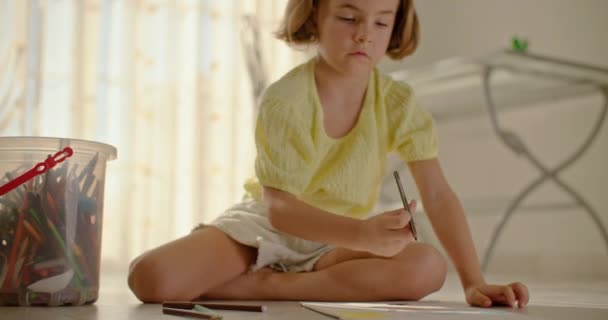 Das Mädchen zeichnet zu Hause mit Bleistiften auf dem Boden. Kind und künstlerische Entwicklung der Weltsicht. Hochwertiges 4k Filmmaterial - Filmmaterial, Video