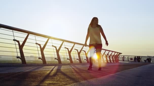 Városi futás start: nő végez Energizing Pre-Run rutin a Cityscape ragyogás napfelkelte. Kiváló minőségű 4k felvételek - Felvétel, videó