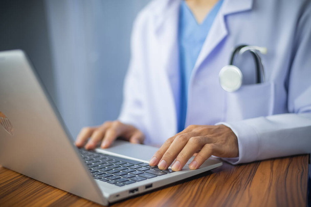 Lekarz korzystający z laptopa na biurku - Zdjęcie, obraz