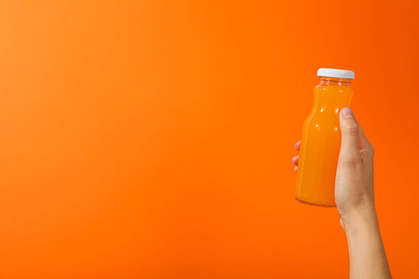 オレンジ色の背景にジュースを手に入れたガラス瓶,テキストのためのスペース - 写真・画像