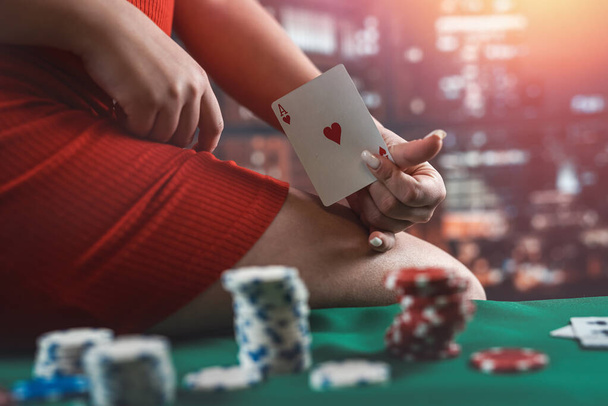Nuori nainen kasino punainen mekko istuu pokeripöydässä pelimerkkejä ja kortteja. Pokeria. viettelevä nainen - Valokuva, kuva