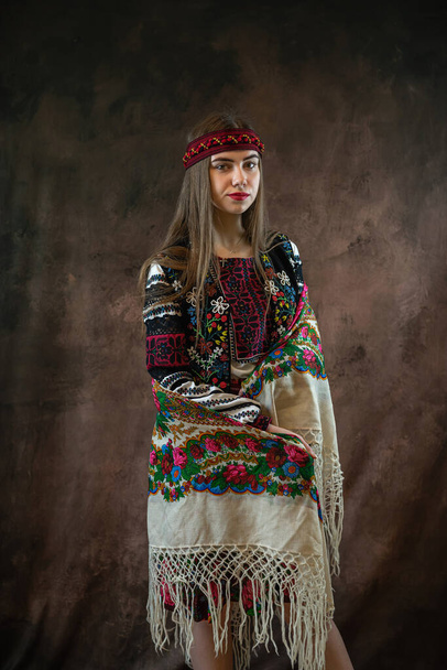 Oekraïense jonge vrouw dragen vyshyvanka traditionele Oekraïense kleding op zwarte achtergrond. Folklore en etnische kleding - Foto, afbeelding
