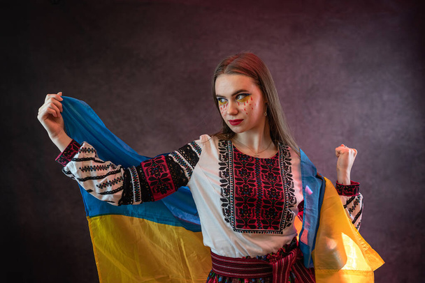 Portrait of beautiful Ukrainian woman patriot in national clothing embroidery with flag request for help to Ukraine. Inviolability of the Ukrainian people, freedom concept - Photo, Image