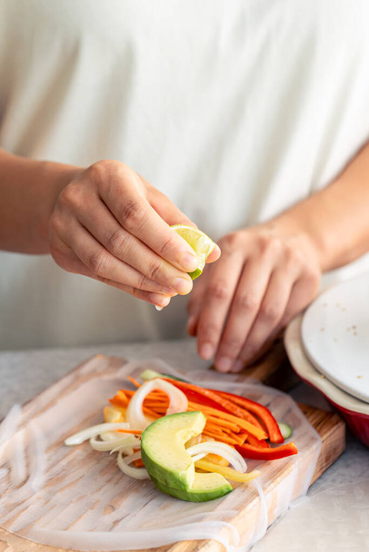 Woman cooks the spring roll with fresh vegetables, appetizing diet asian dish. - Photo, Image