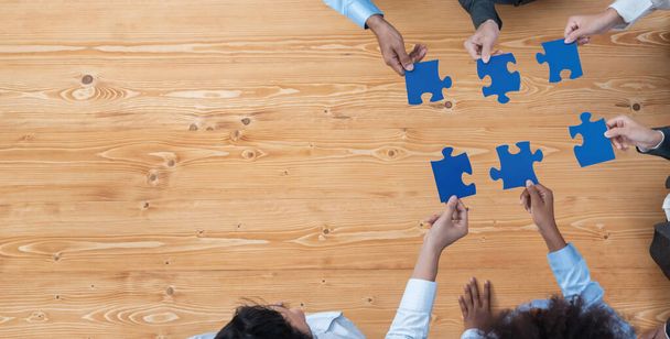 Panorama von oben Diverse Corporate Officers arbeiten im Büro zusammen und verbinden Puzzleteile als Partnerschafts- und Teamwork-Konzept. Einheit und Synergien im geschäftlichen Erfolg mit Puzzle. Eintracht - Foto, Bild