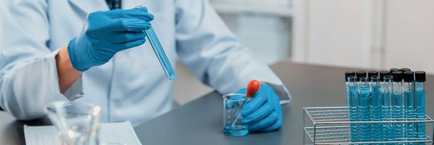 Gli scienziati conducono esperimenti chimici in laboratorio medico, rilasciano con attenzione quantità precise di liquido dalla pipetta nella provetta per il farmaco vaccinale o lo sviluppo di antibiotici. Neoterici - Foto, immagini