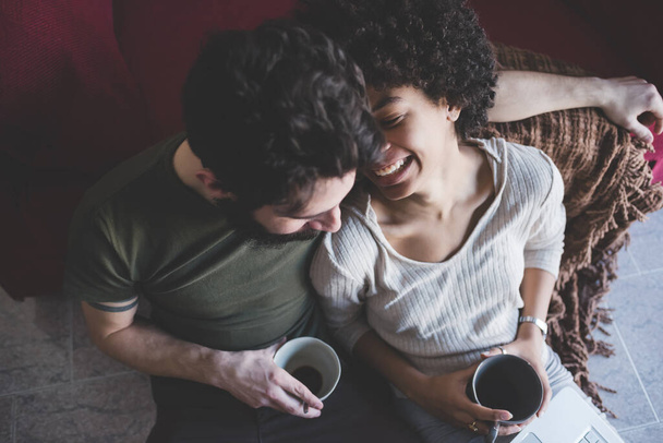 Jovem casal multiétnico usando pc tendo café  - Foto, Imagem