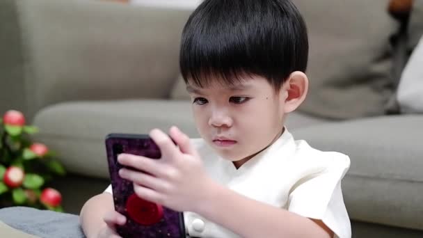 Asiatico ragazzo holding su mani per comunicare con gli amici in linea aula via cellulare - Filmati, video