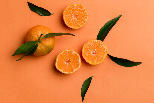 Muchos mandarina madura fresca con hojas verdes sobre fondo de color, vista superior, espacio para el texto. - Foto, imagen