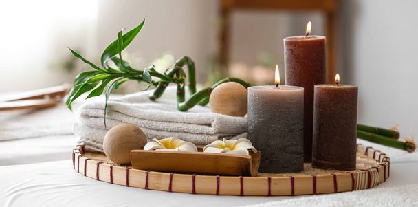 Velas ardientes, bolas de masaje, torres y flores en el salón de spa - Foto, imagen