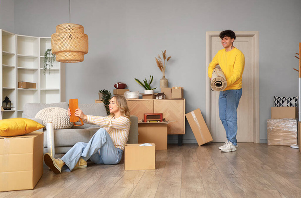 Jeune couple emballant des choses dans la chambre le jour du déménagement - Photo, image