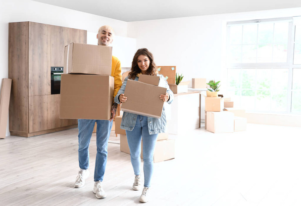 Young couple with cardboard boxes in kitchen on moving day - Photo, Image