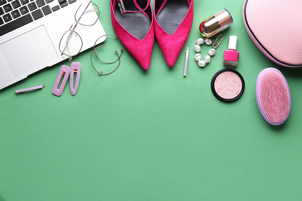 Samenstelling met moderne laptop, stijlvolle vrouwelijke accessoires en cosmetica op kleur achtergrond - Foto, afbeelding