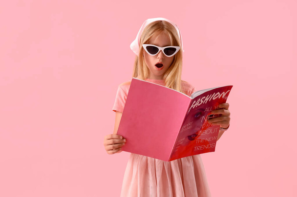 Ragazza che legge rivista di moda su sfondo rosa - Foto, immagini