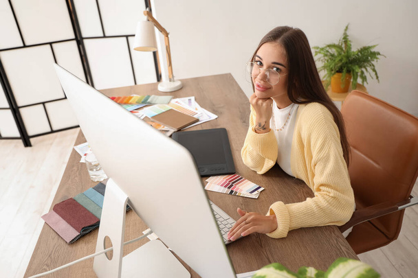 オフィスのテーブルでコンピュータを操作する女性インテリアデザイナー - 写真・画像