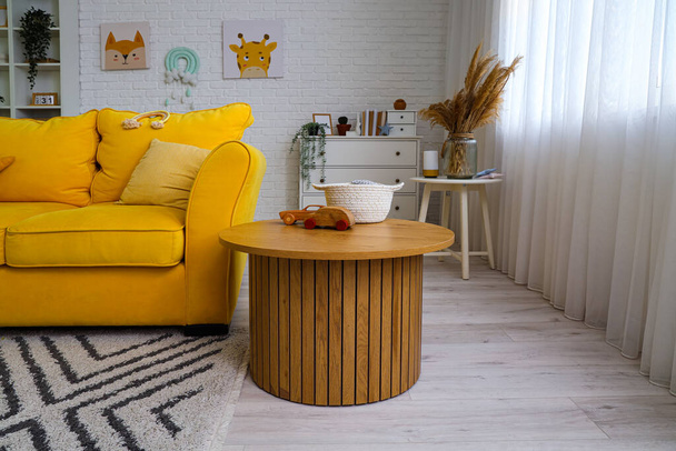 Sisätilojen lastenhuone keltainen sohva ja pöytä - Valokuva, kuva