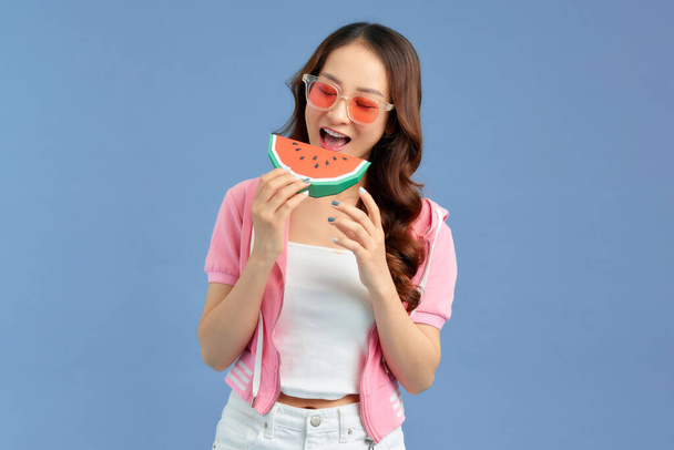 Beautiful young woman holding slice of watermelon and smiling on color background - Photo, Image
