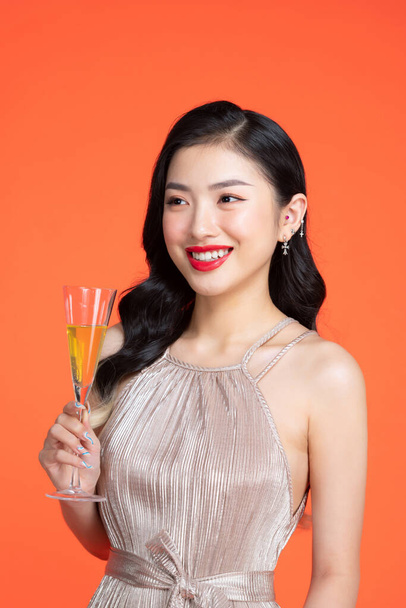 charming cheerful young lady hold sparkling wine enjoy occasion isolated on red color background - Photo, Image