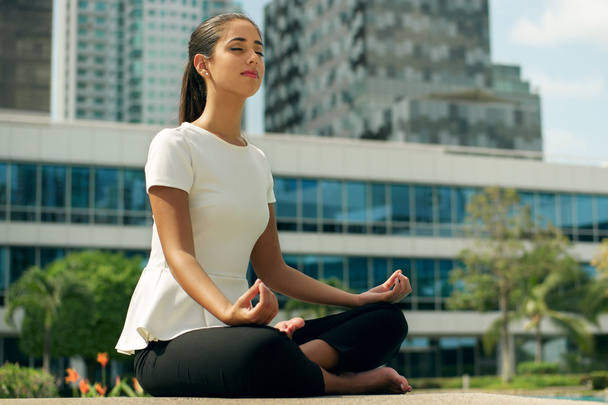 Ontspannen zakelijke vrouw Yoga Lotus positie buiten Office gebouw - Foto, afbeelding