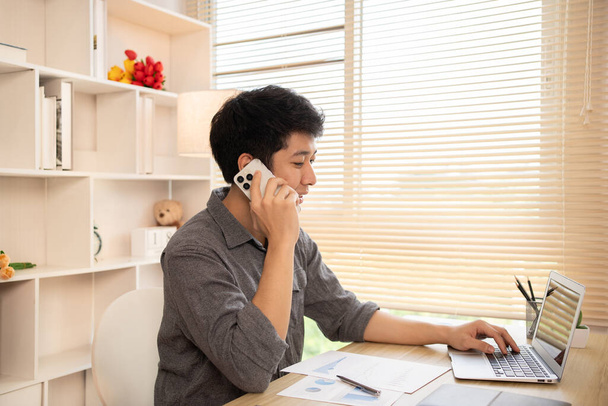 Молодой бизнесмен разговаривает по телефону с клиентом для ведения переговоров о бизнесе, междугородней связи, ведения переговоров о сделке по телефону. - Фото, изображение