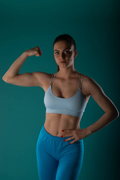 Уверенная в себе женщина фитнес-модель достижения мощных результатов в студии выстрел - Фото, изображение