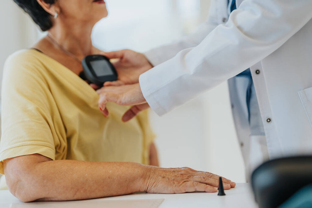 Un medico esamina una donna anziana, controllando la frequenza cardiaca e la pressione sanguigna in una clinica interna. Discutono della sua salute e forniscono assistenza medica professionale. - Foto, immagini