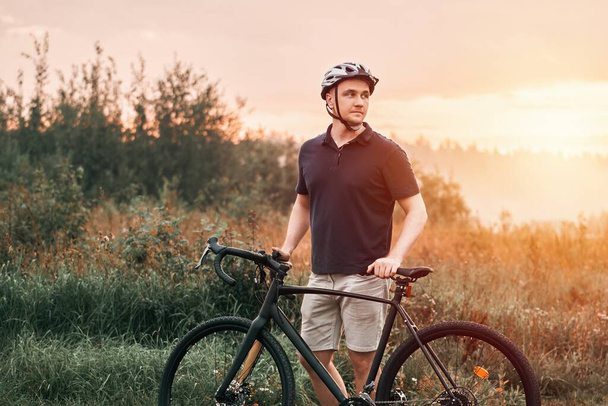 スリリング・グラベル・ライド。 自転車で行動する男. アウトドアアドベンチャー。 自然の中でグラベルバイクライドを楽しむサイクリスト - 写真・画像