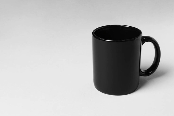 Black ceramic mug on light grey background. Space for text - Foto, Imagem