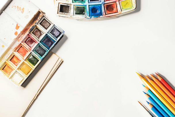 Мистецьке робоче місце, акварельна палітра та кольорові олівці - Фото, зображення