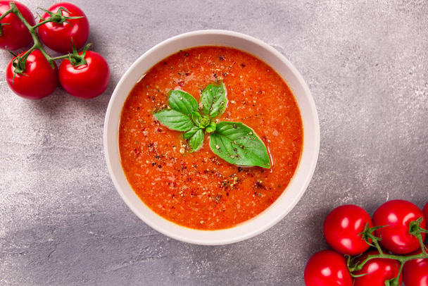Homemade tomato cream soup with basil and spices on gray background - Photo, Image