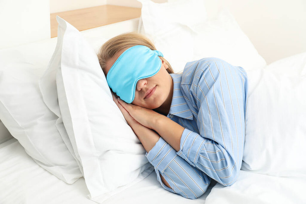 Μια νεαρή γυναίκα κοιμάται με μάσκα ύπνου. - Φωτογραφία, εικόνα