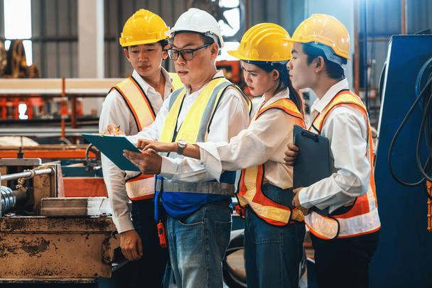 Group of engineer with factory foreman or supervisor oversee training program or conduct safety inspection on metalwork manufacturing machine in heavy industrial factory. Exemplifying - Photo, Image