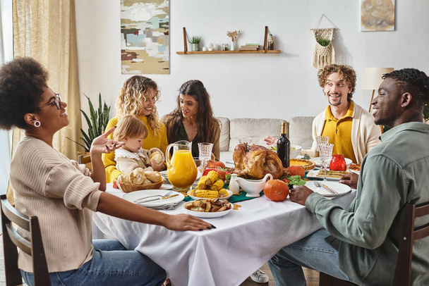 happy multiracial family and friends talking and smiling during Thanksgiving dinner, festive joy - Zdjęcie, obraz