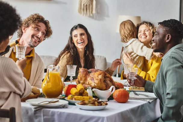 ευτυχισμένη πολυπολιτισμική οικογένεια και φίλοι που έχουν δείπνο διακοπών μαζί την ημέρα των Ευχαριστιών - Φωτογραφία, εικόνα