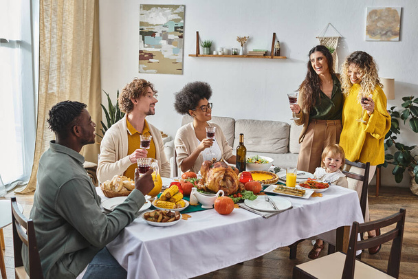 interracial family enjoying Thanksgiving dinner, happy toddler child sitting near lgbt parents - Foto, Imagem