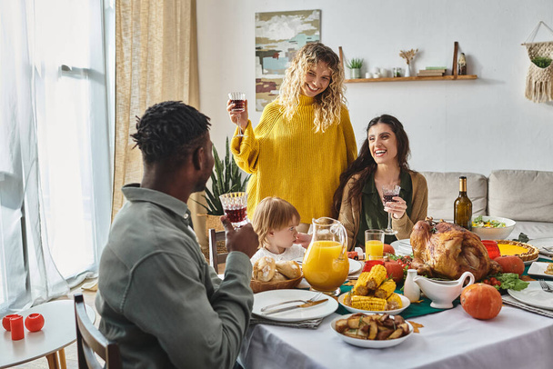 vreugdevolle lgbt familie vieren Thanksgiving met peuter baby meisje en Afrikaanse Amerikaanse man - Foto, afbeelding