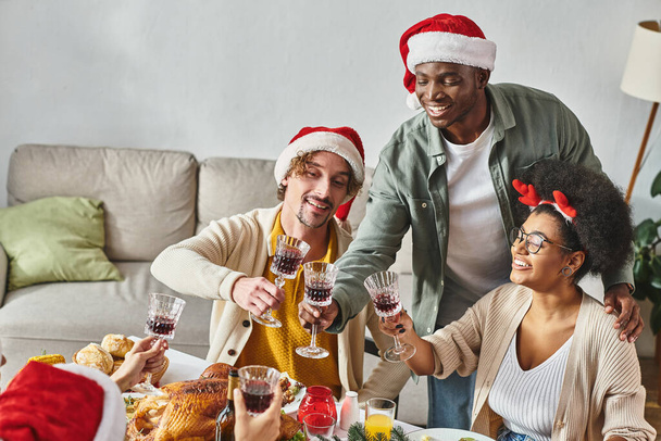 big multiethnic family sitting and clinking their wine glasses at holiday table, Christmas - Photo, Image