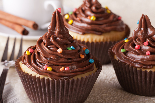 Cupcakes mit Schokoladencreme in Nahaufnahme und Kaffee, horizontal - Foto, Bild