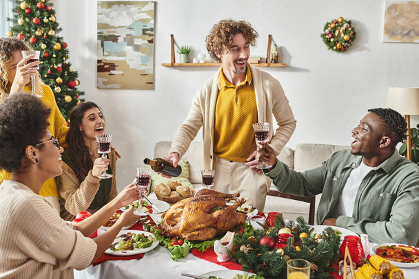 velká veselá multiraciální rodina mají skvělý čas se smát a pít víno, vánoční den - Fotografie, Obrázek