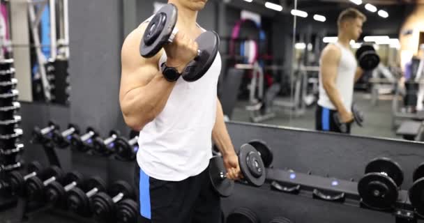 Homem atlético a levantar halteres na sala de fitness. Treinamento de força e musculação - Filmagem, Vídeo