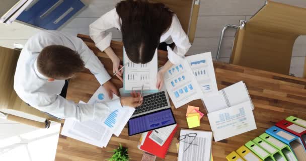 Obchodní partneři studující grafy v dokumentech a na notebooku v kanceláři top view. Koncept podnikatelské inteligence a analýza dat - Záběry, video
