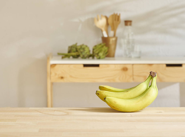 Μπανάνα στο ξύλινο τραπέζι και κουζίνα στυλ φόντου. - Φωτογραφία, εικόνα