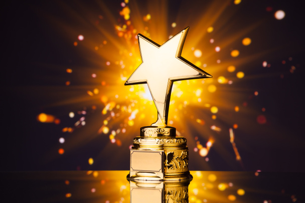 gold star trophy against shiny sparks background - Photo, Image