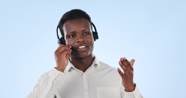 Zwarte man, call center en consulting op koptelefoon in de klantenservice tegen een blauwe studio achtergrond. Afrikaanse zakenman, consultant of agent in gesprek op headset in online advies over mockup space. - Video