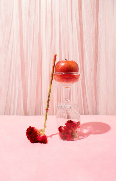 Stillleben-Arrangement aus Kristallgläsern gefüllt mit roten Äpfeln und Celosia-Blüten. Kreativer Kopierraum - Foto, Bild