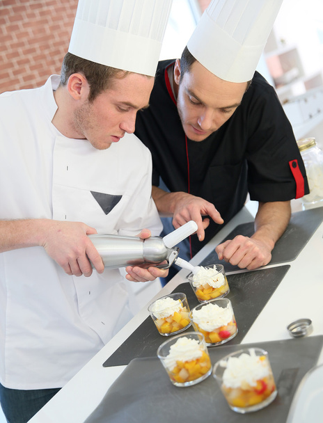 Cook preparing dessert with chef - Foto, Bild