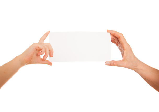 Ruka dospělého a dítěte držel bílý papír, karton. Bílé pozadí s prostorem pro text - Fotografie, Obrázek